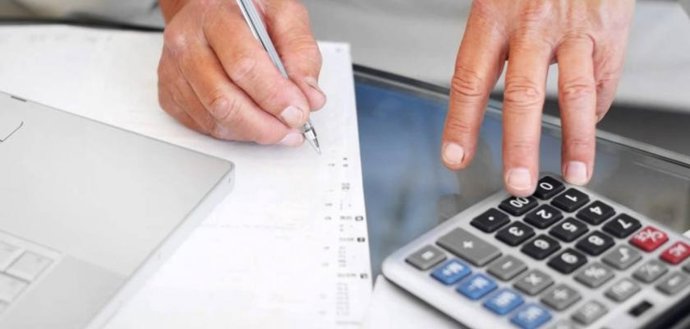 Archivo - Una persona realiza cáculos con una calculadora, en una imagen de archivo.