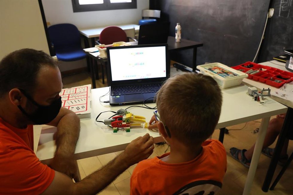 Archivo - Imagen de archivo de un monitor y un niño junto a un ordenador