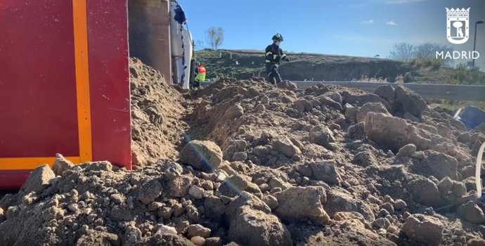 Vuelva un camión cargado de arena en una rotonda de Vallecas y el chófer resulta herido leve