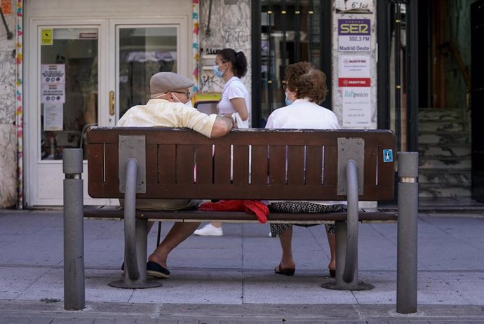Archivo - Una pareja de ancianos con mascarilla sentada en un banco.