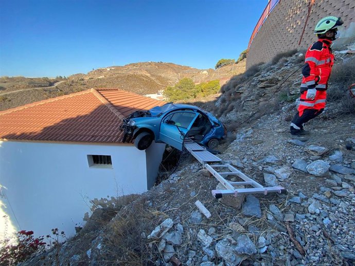Coche sobre el tejado de una casa tras un accidente en La Rábita