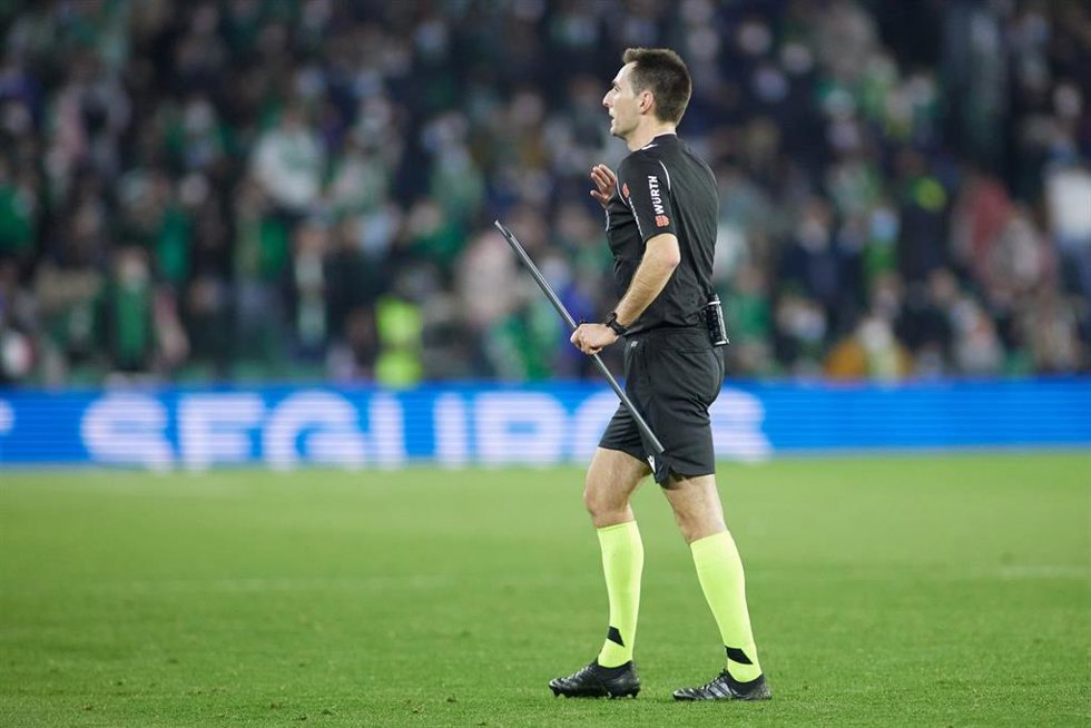 El árbitro del derbi entre Betis y Sevilla, antes de suspender el partido por el lanzamiento de una barra de plástico que golpeó a un jugador 