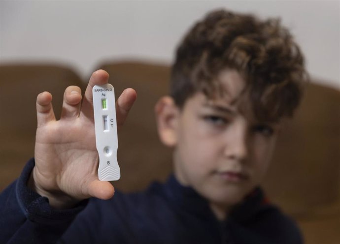 Un niño enseña un test de antígenos, a 16 de enero de 2022, en Madrid, (España). El Boletín Oficial del Estado (BOE) ha publicado el acuerdo de la Comisión Interministerial de Precios de los Medicamentos (CIMP) para fijar un precio máximo de venta al pú