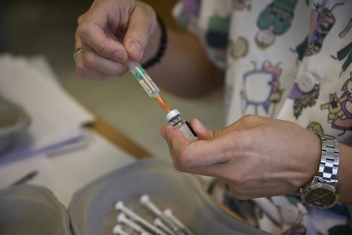 Archivo - Un profesional sanitario sostiene un vial con la vacuna contra el Covid-19