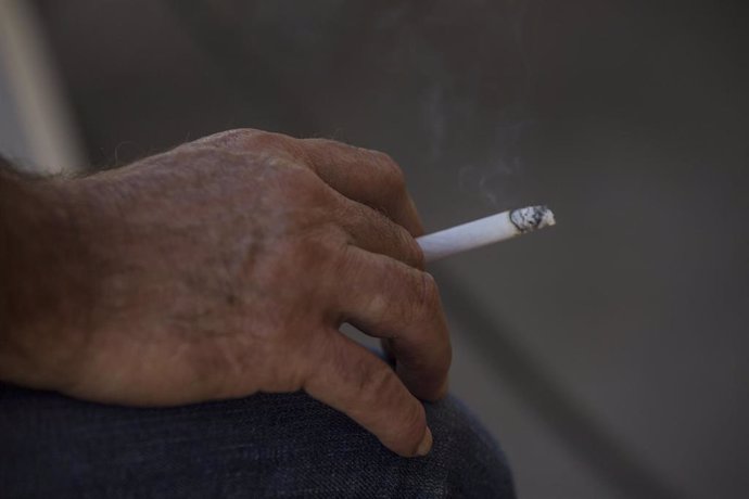 Archivo - Una persona fuma en la terraza de un bar durante el primer día de la prohibición en la vía pública en Andalucía si no existe una distancia de dos metros de separación para evitar contagios de Covid-19. En Sevilla (Andalucía), a 17 de agosto de