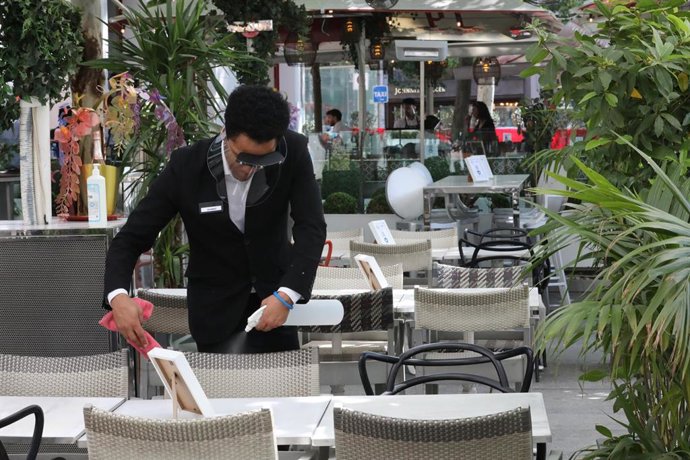 Archivo - Un camarero prepara una mesa de una céntrica terraza madrileña en el primer día de la Fase 1, cuando se reabren al público las terrazas al aire libre de los establecimientos de hostelería y restauración limitándose al 50% de las mesas y garant