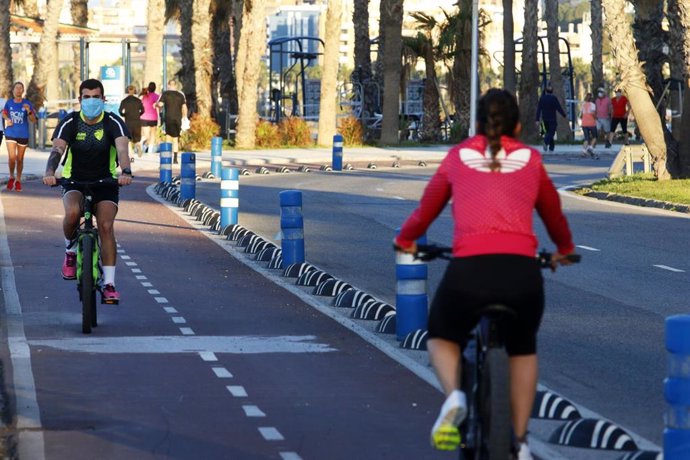 Archivo - Varias personas pasean en bicicleta por un carril bici en Málaga capital