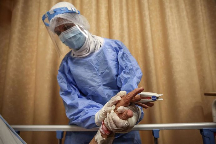 Archivo - 26 April 2021, Egypt, Cairo: Nurse Mona Gaber, 38, wearing full protective gear, tends to a patient on oxygen support, inside the Intensive Care Unit (ICU) of Heliopolis hospital, which is currently serving as an isolation hospital for COVID-1