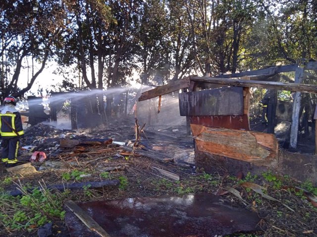 Extinción de un incendio en una casa de madera abandonada en la calle Solar (Gijón), ocupada ocasionalmente por indigentes