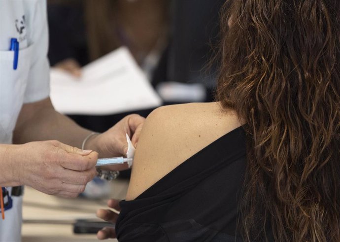 Una mujer recibe la tercera dosis de la vacuna contra el Covid-19, en el Hospital Enfermera Isabel Zendal, a 13 de enero de 2022, en Madrid, (España).