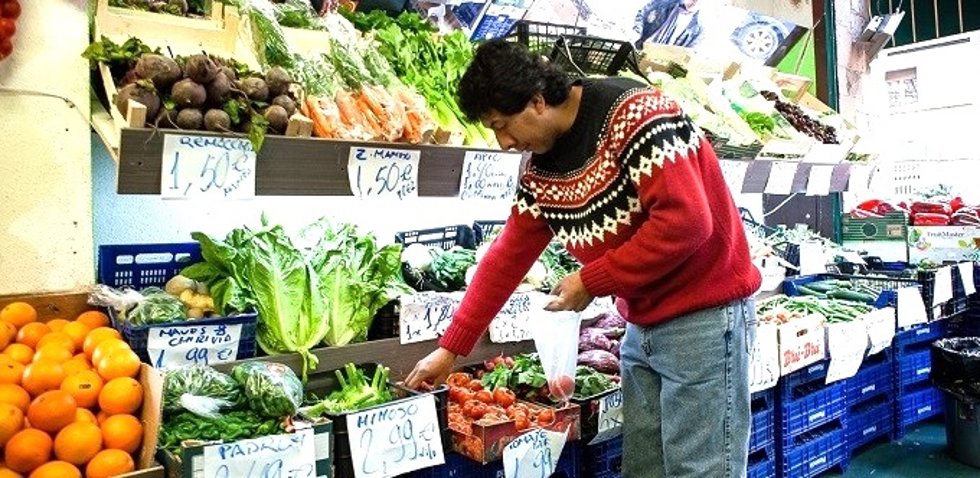 Un hombre comprando en el puesto de fruta y verdura.
