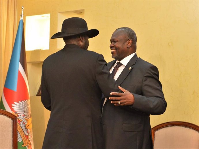 Archivo - El vicepresidente primero de Sudán del Sur, Riek Machar (d), se abraza con el presidente del país, Salva Kiir