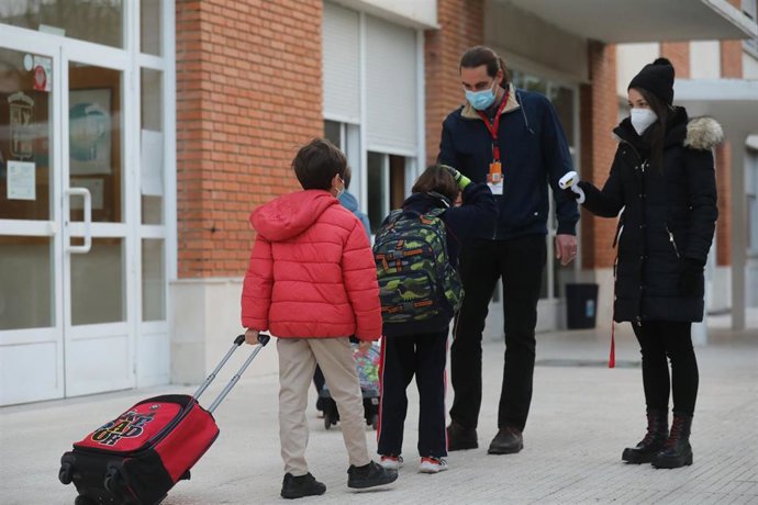 Un trabajador toma la temperatura a un niño a su llegada al colegio.- Archivo