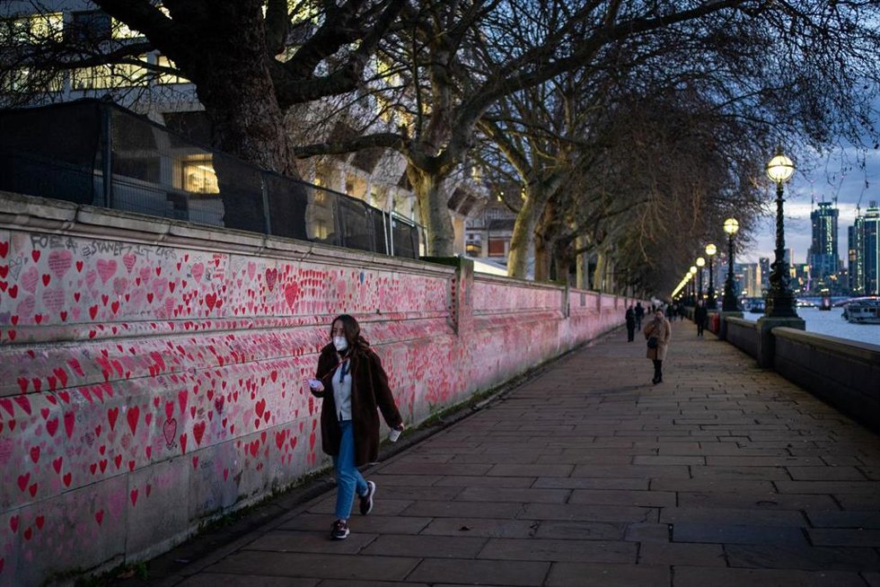 Personas caminan frente al mural homenaje a las víctimas de la COVID-19 en Londres, la capital de Reino Unido.