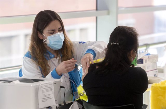 Una mujer recibe la tercera dosis de la vacuna contra el Covid-19, en el WiZink Center