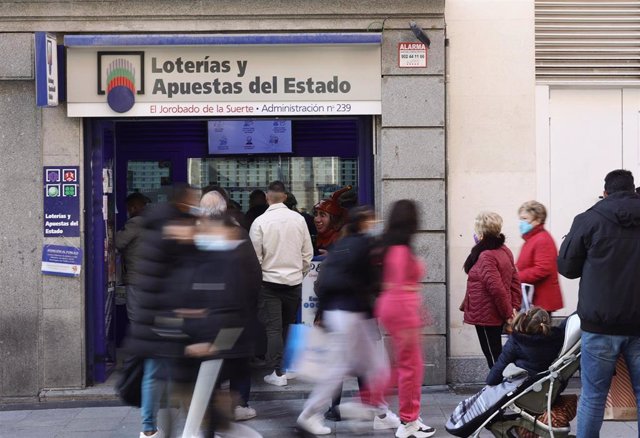 Varias personas en las inmediaciones de la administración de loterías 'El jorobado de la suerte', tres días antes del Sorteo de La Lotería del Niño, a 3 de enero de 2022, en Madrid, (España). 