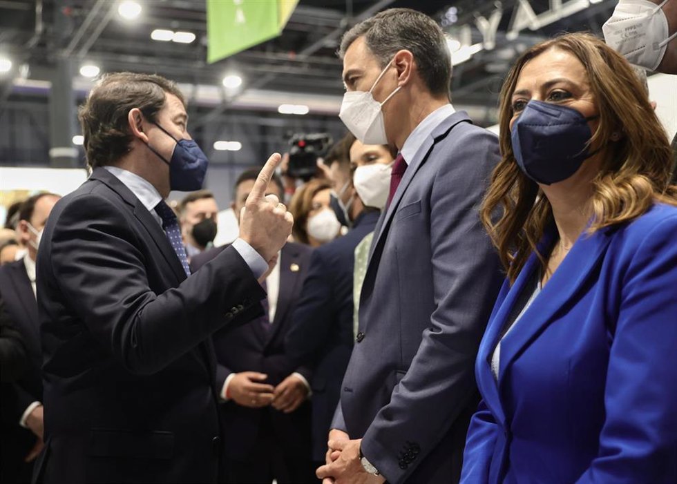 El presidente del Gobierno, Pedro Sánchez, charla con el presidente del Partido Popular de Castilla y León, Alfonso Fernández Mañueco, en la tercera jornada de la 42 edición de la Feria Internacional del Turismo, Fitur 2022, en Ifema Madrid.