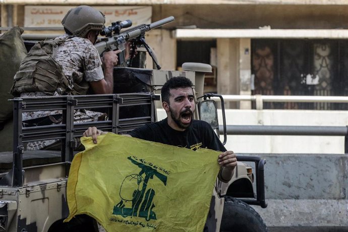 Archivo - Un hombre en Líbano con una bandera de Hezbolá.