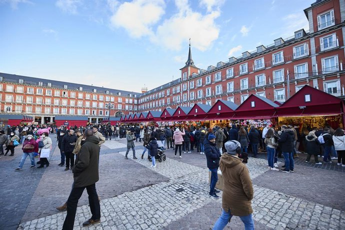 Archivo - Un grupo de personas asiste al mercadillo navideño instalado en la madrileña plaza mayor, a 5 de diciembre de 2021, en Madrid (España).  