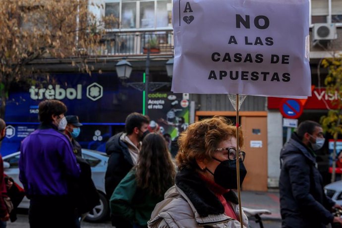 Archivo - Una mujer sostiene una pancarta donde se lee "No a las casas de apuestas" en una manifestación contra la proliferación de los locales de apuestas en el barrio madrileño de Carabanchel