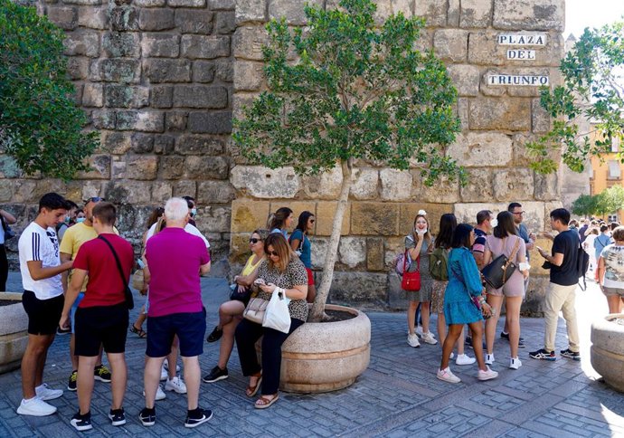 Archivo - Colas de turistas en las puertas del Alcázar de Sevilla, en una foto de archivo.