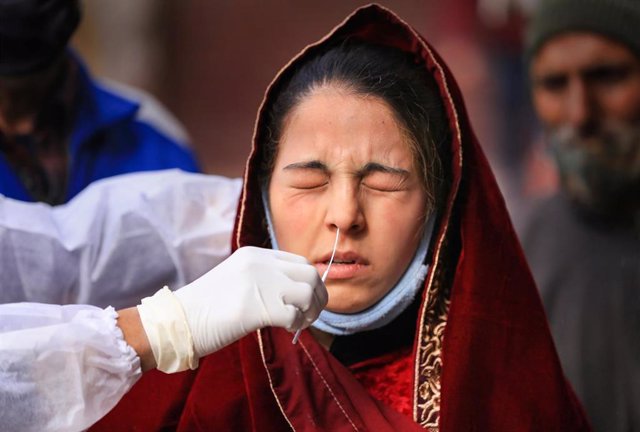  Un trabajador sanitario recoge muestras de una mujer para la prueba del COVID-19 en Jammu, India.