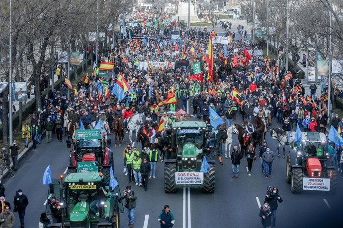 Personas a caballo con banderas de España, tractores y manifestantes en la movilización en defensa del campo y del mundo rural y la futura Ley de Protección Animal, en el Paseo de la Castellana, a 23 de enero de 2022, en Madrid.