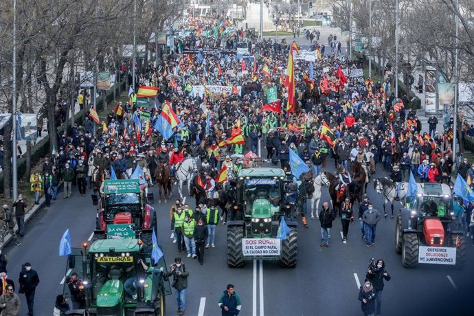 Personas a caballo con banderas de España, tractores y manifestantes en la movilización en defensa del campo y del mundo rural y la futura Ley de Protección Animal, en el Paseo de la Castellana, a 23 de enero de 2022, en Madrid (España).