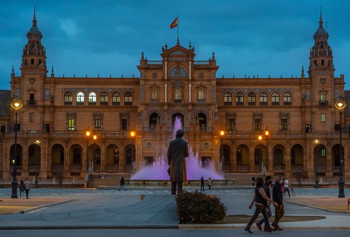 Archivo - Fuente de la Plaza de España, con luces violeta por el día internacional de la mujer. Sevilla a 08 de marzo 2021
