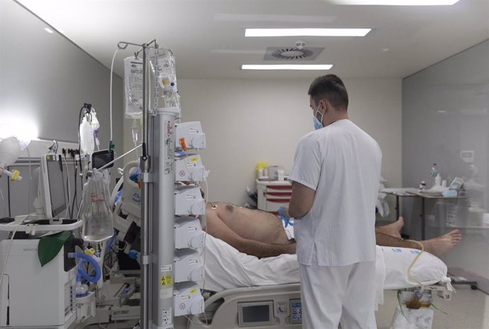 Un sanitario alrededor de un paciente ingresado en la UCI del Hospital Enfermera Isabel Zendal, a 13 de enero de 2022, en Madrid (España). 