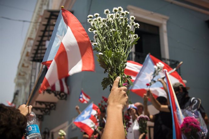 Archivo - 24 July 2019, Puerto Rico, San Juan: People hold placards and flags as they take part in a protest in front of the residence of Governor Rossello, also known as La Fortaleza. The protests are against the Puerto Rican governor Ricardo 'Ricky' A