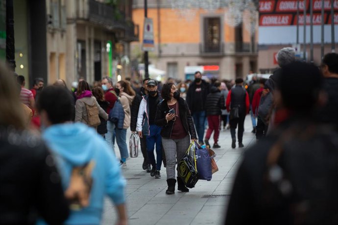 Viandantes tras realizar compras de Navidad