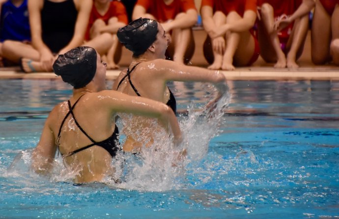 Dos deportistas haciendo natación sincronizada.