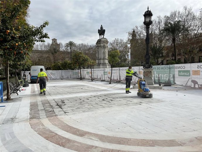 Operarios aplicando el tratamiento antideslizante en la Plaza Nueva de Sevilla.