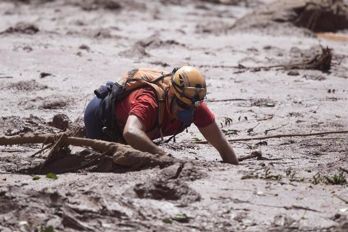 Archivo - Un trabajador busca a personas desaparecidas tras el derrumbe de una presa en Brasil.