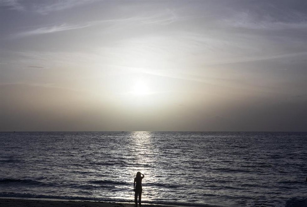 Archivo - A woman watches an almost colourless sunrise over Palm Beach in Florida. Photo: Lannis Waters/Palm Beach Post via ZUMA Wire/dpa