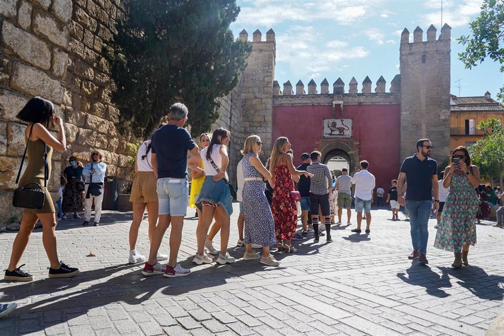 Archivo - Colas de turistas en las puertas del Alcázar de Sevilla, en foto de archivo.