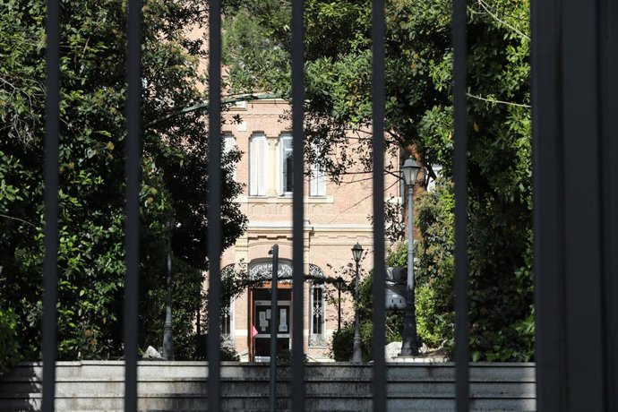 Archivo - Verja a través de la cual se observa un jardín y una residencia.