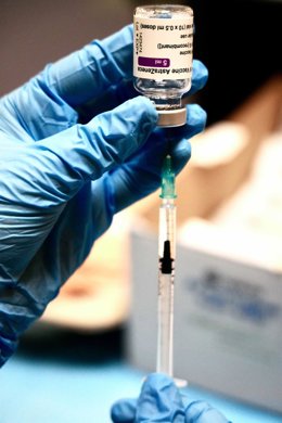 Archivo - Una profesional sanitaria sostiene una jeringuilla con un vial de la vacuna contra la COVID-19 