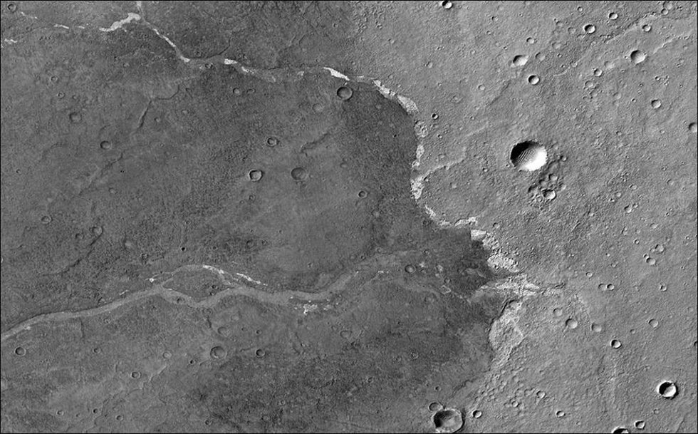 El Orbitador de Reconocimiento de Marte de la NASA usó su cámara de contexto para capturar esta imagen de Bosporos Planum, una ubicación en Marte. Las motas blancas son depósitos de sal que se encuentran dentro de un canal seco.