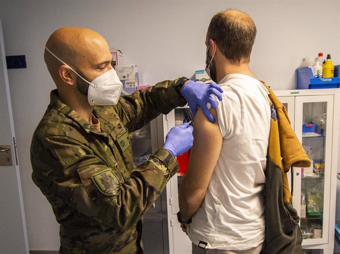 Un militar de la BRI X pone a un hombre una vacuna contra el Covid-19.