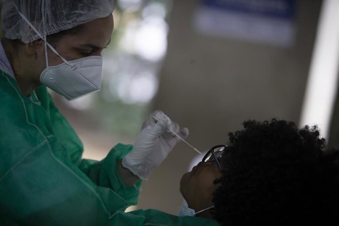 11 January 2022, Brazil, Rio de Janeiro: A health worker takes a swab from a person for a Coronavirus (Covid-19) test at a new testing center inaugurated by the Rio City Hall at Ciep Doutor Antoine Magarinos Torres Filho. Photo: O Globo/GDA via ZUMA Pre