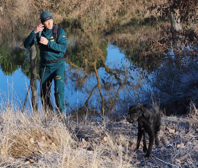 Un agente acompañado de un perro adiestrado busca en las inmediaciones del río Duero el rastro de la mujer desaparecida.