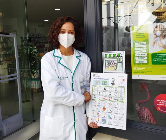 Una farmacéutica muestra un pictograma para mejorar la atención a personas con TEA.