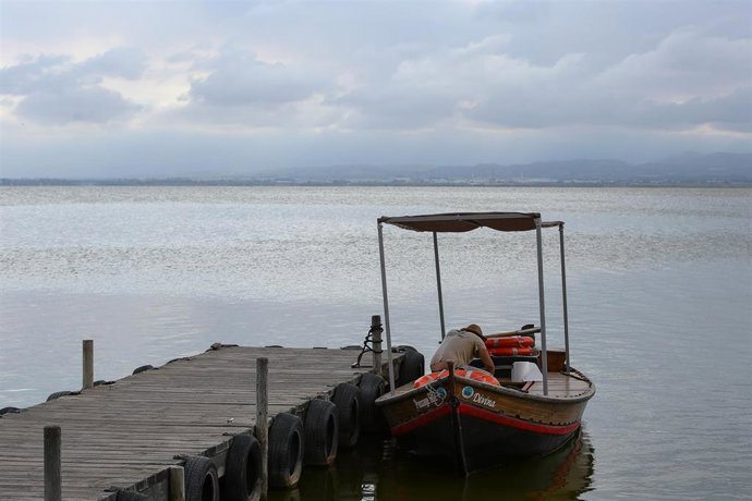 Archivo - Un tripulante espera en su barca atracada en el embarcadero del Parque Natural de La Albufera en las inmediaciones de la localidad de El Palmar, en Valencia