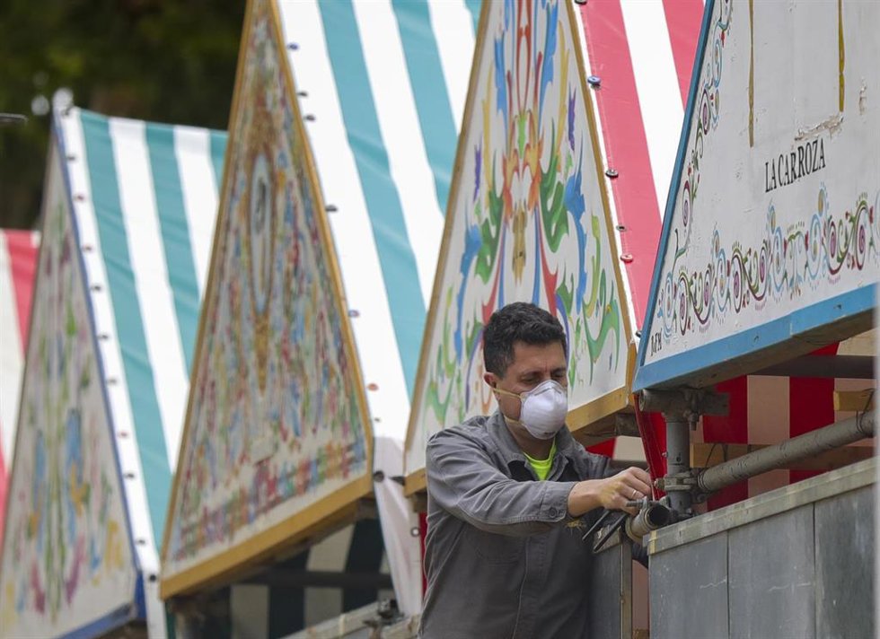 Archivo - Un operario trabaja en la instalación de una caseta de la Feria de Abril, en foto de archivo.