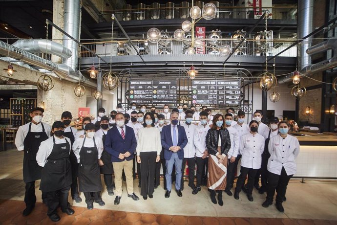 El consejero de Presidencia, Elías Bendodo, se hace una fotografía con los alumnos de la Escuela de Hostelería durante la visita la Factoría Cruzcampo, a 27 de enero de 2022 en Sevilla (Andalucía, España)