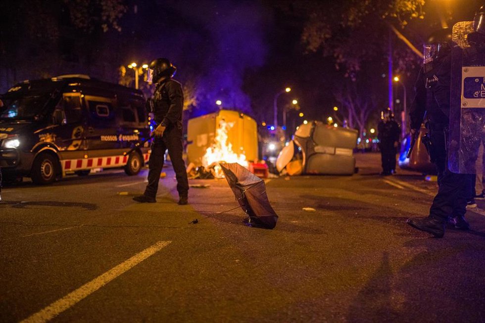 Archivo - Varios mossos antidisturbios pasan delante de un contenedor quemado en la plaza Urquinaona durante una manifestación por el referéndum del 1-O en Cataluña, a 1 de octubre de 2021, en Barcelona, Cataluña (España). El independentismo catalán cel