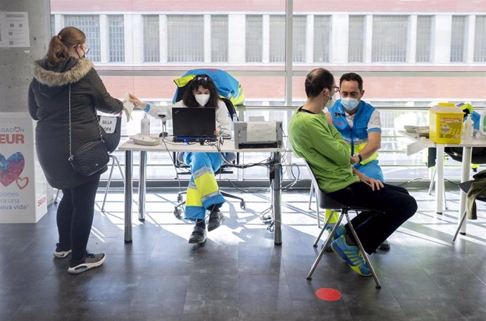 Dos personas son vacunadas contra el Covid-19, en el WiZink Center, a 20 de enero de 2022, en Madrid, (España).
