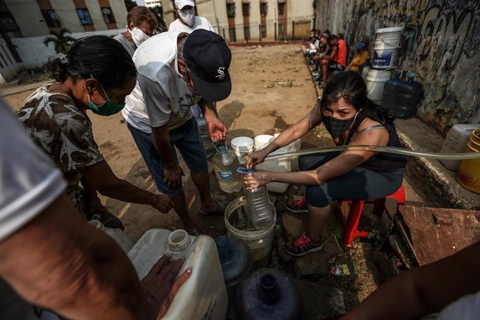 Archivo - Imagen de archivo de venezolanos recogiendo agua